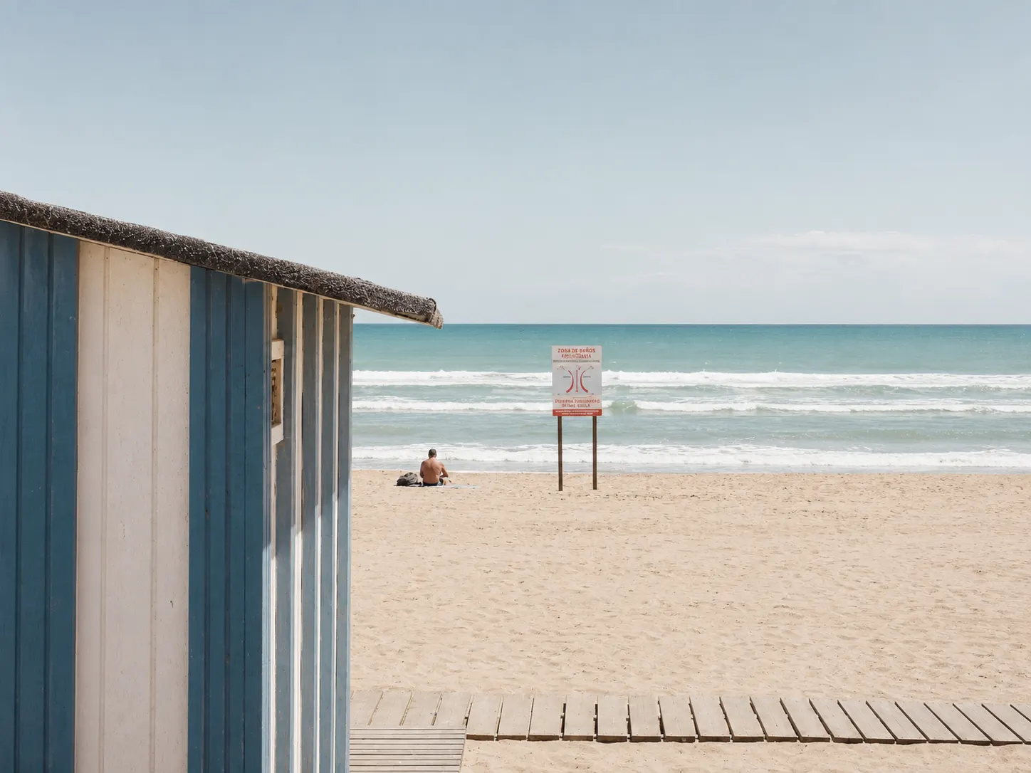 Caseta de playa y cartel de zona de baño en la Costa Blanca